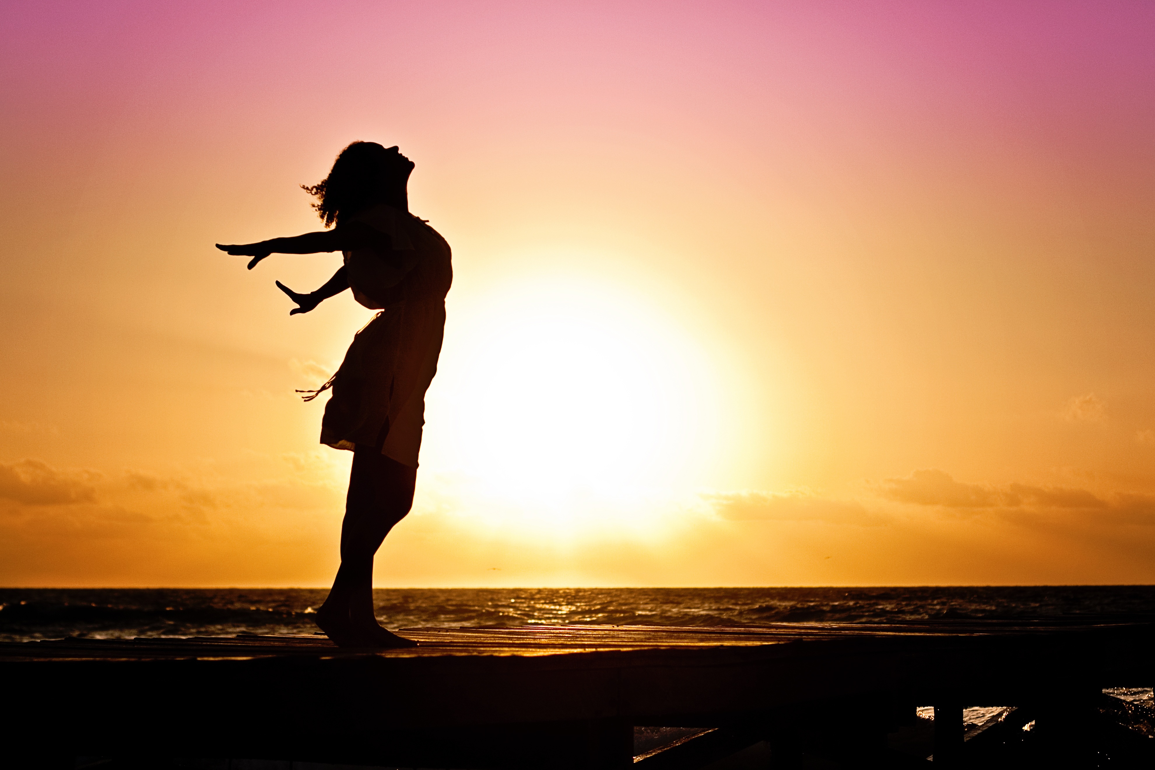 Woman basking in the sunset on the beach