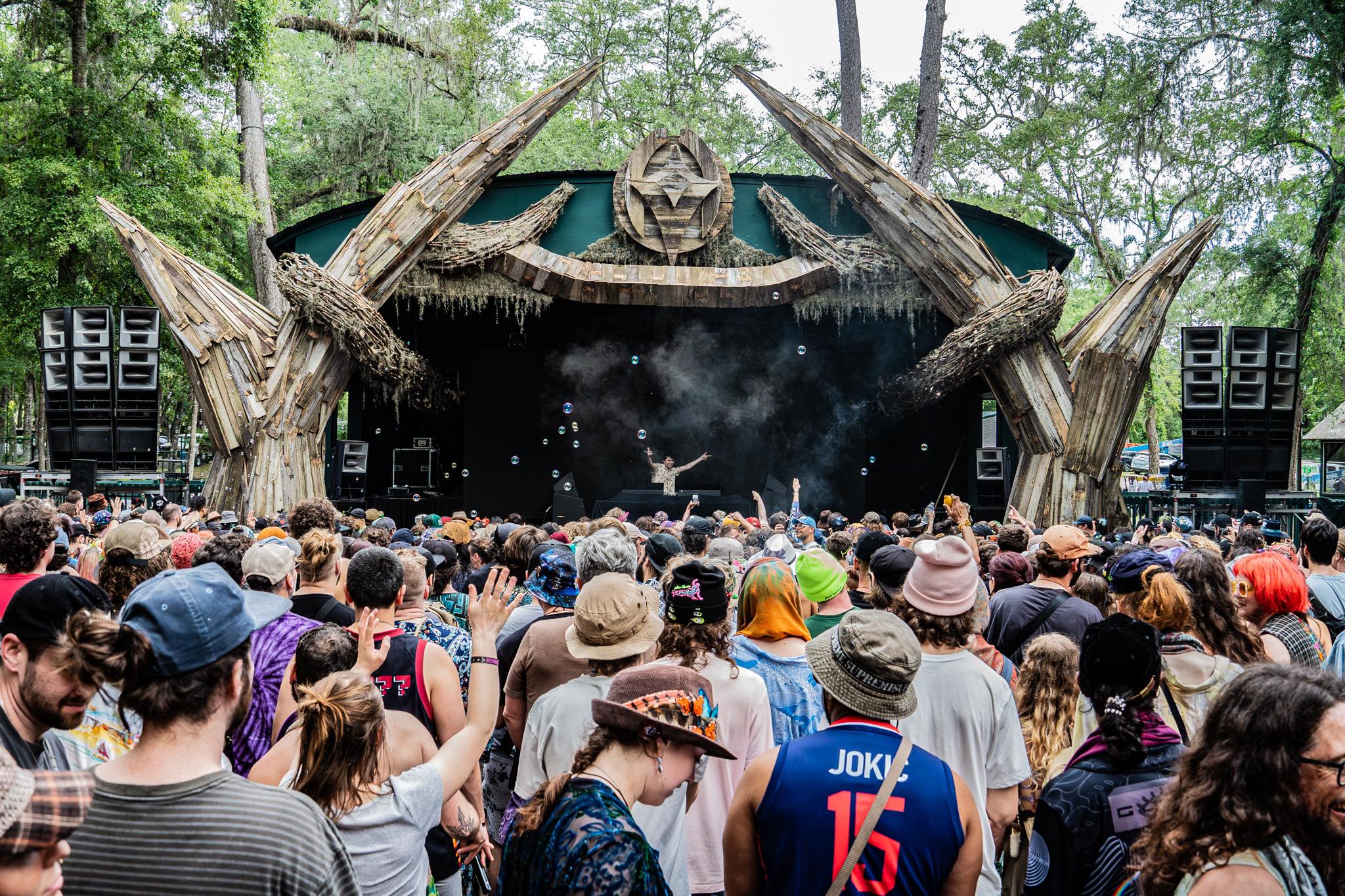 A large crowd dancing in front of Rendezvous tree house stage with Crawdad Sniper djing