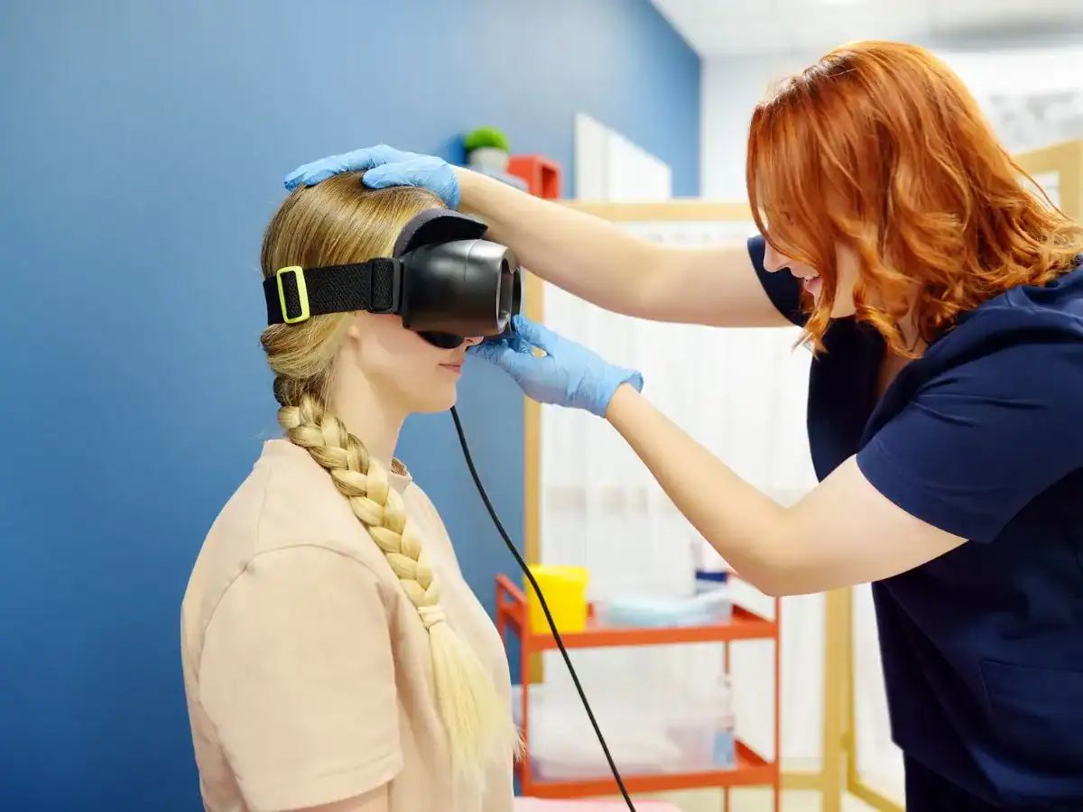 Audiologist performing balance testing using virtual reality headset