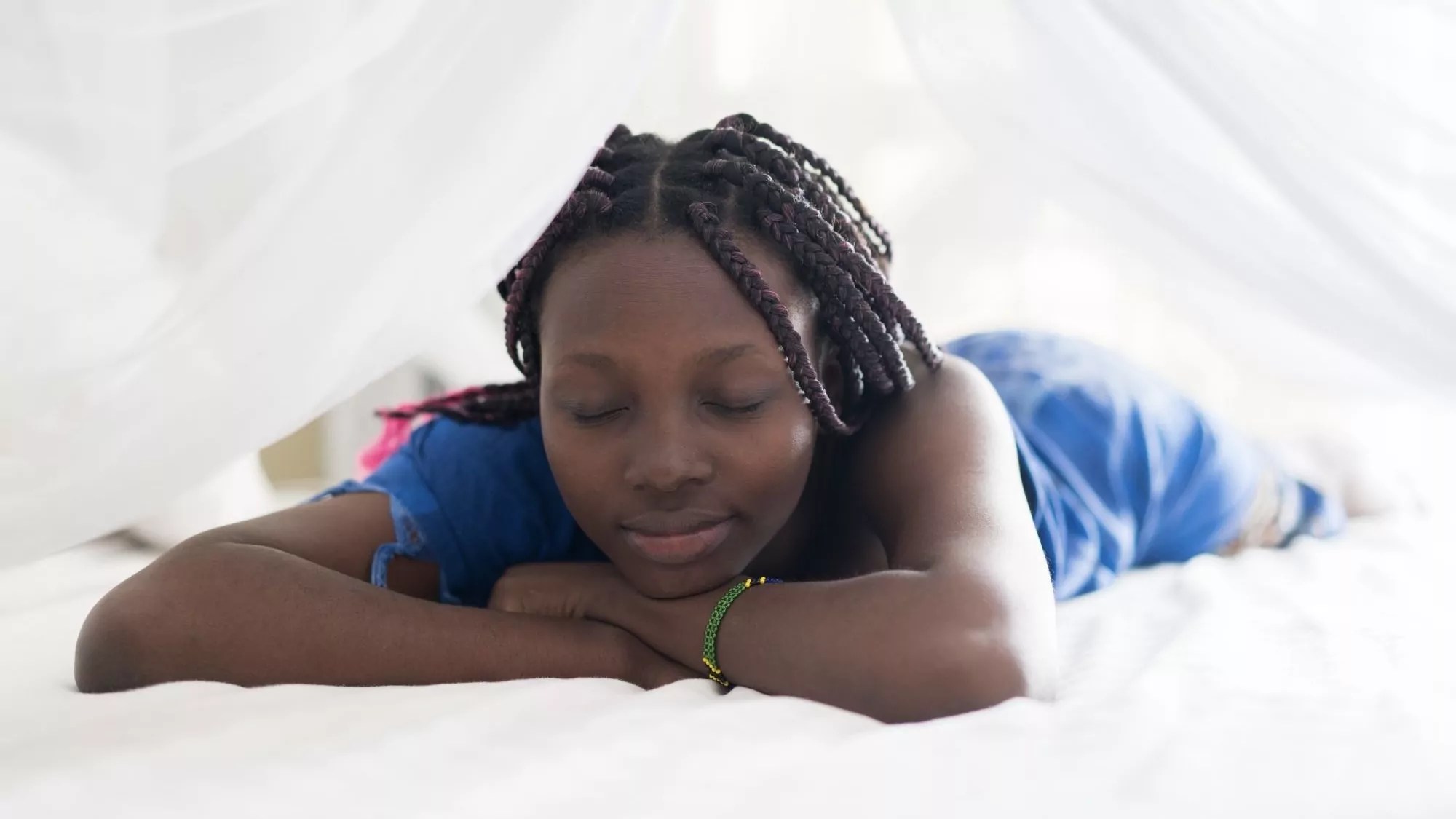 Picture of lady lying on bed with eyes closed