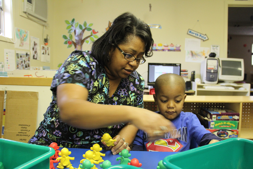 Jennifer Calvert, director of the ABC Pre-School & Nursery Inc. in Aberdeen, Miss., helps a student build a pattern during a morning activity. (Photo: Jackie Mader)