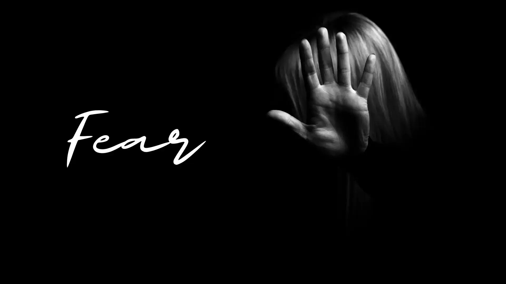 Black and white image of a woman holding her hand up.