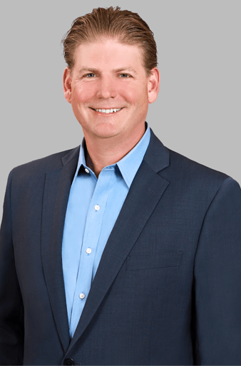 Dr. Daniel Glauber, cybersecurity leader, smiling in professional attire, showcasing expertise in digital security and regulatory compliance.