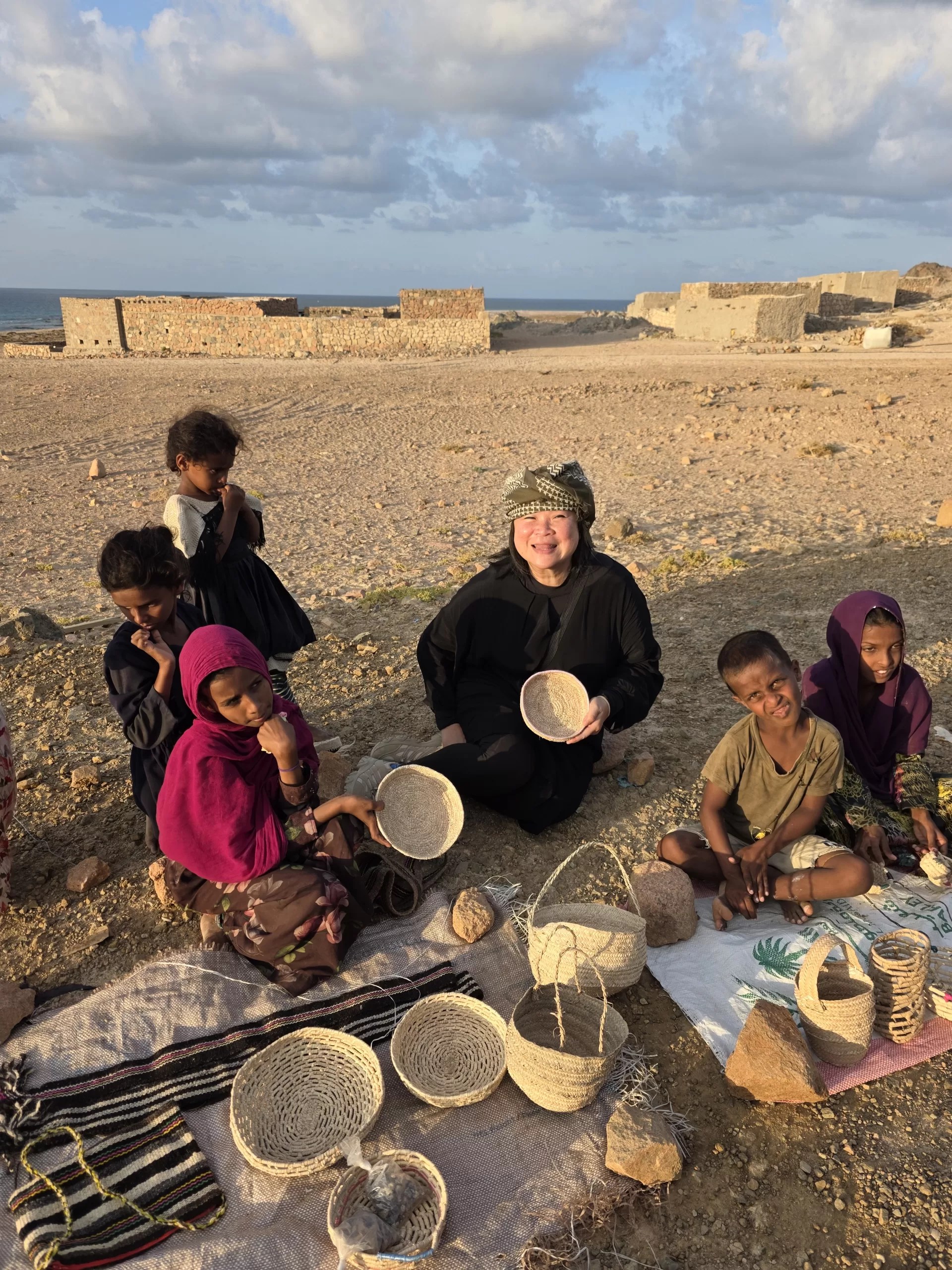 Tourists with local kids selling handicraft products