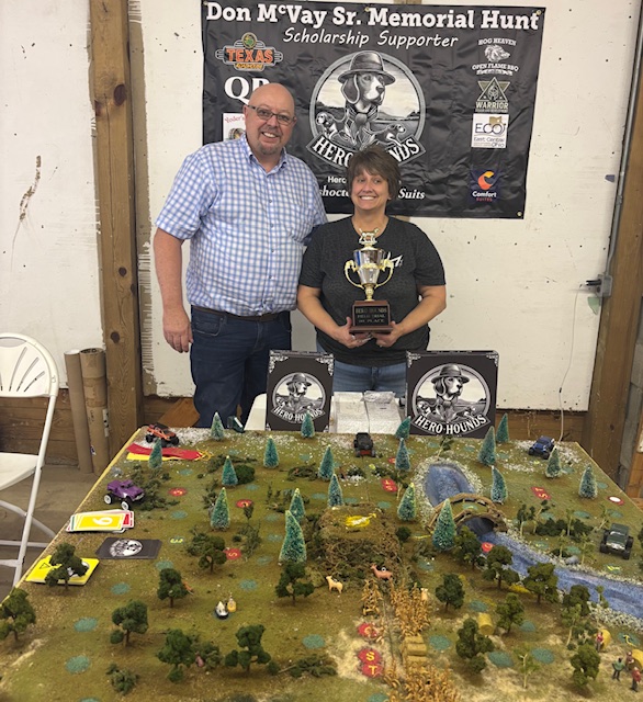 Game creator Joe McVay posing with the winner of the Hero Hounds tournament at the Don McVay Sr Memorial Hunt in front of the three dimensional model of the game