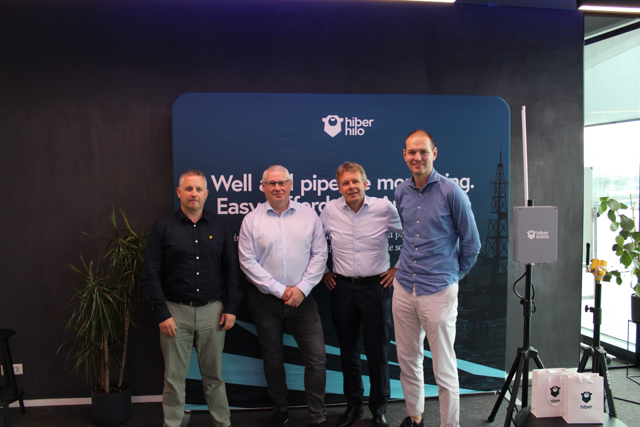 partners of hiber standing in front of a banner