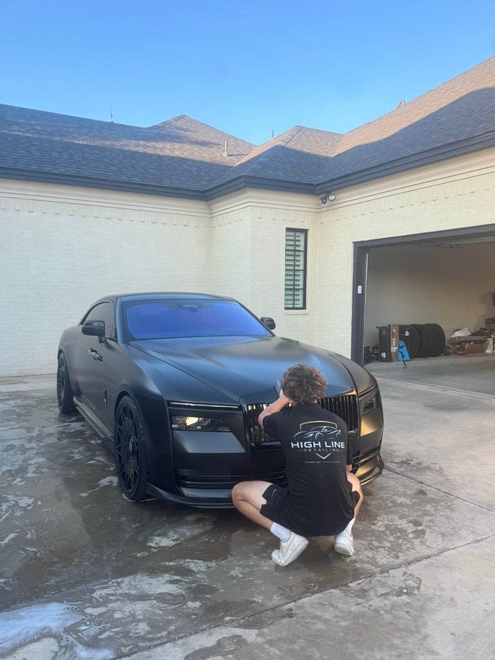 Tylen Brothers hand-detailing the grille of a client vehicle on-site