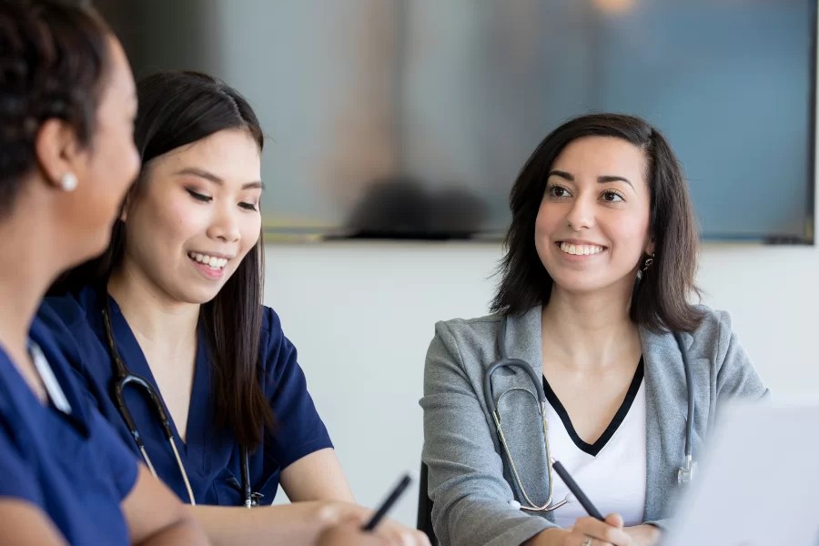 two women smiling while writing notes