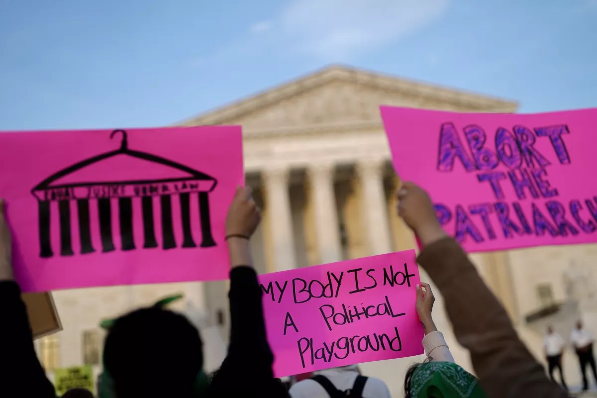 a photo of people holding up sings saying abort the patriarchy