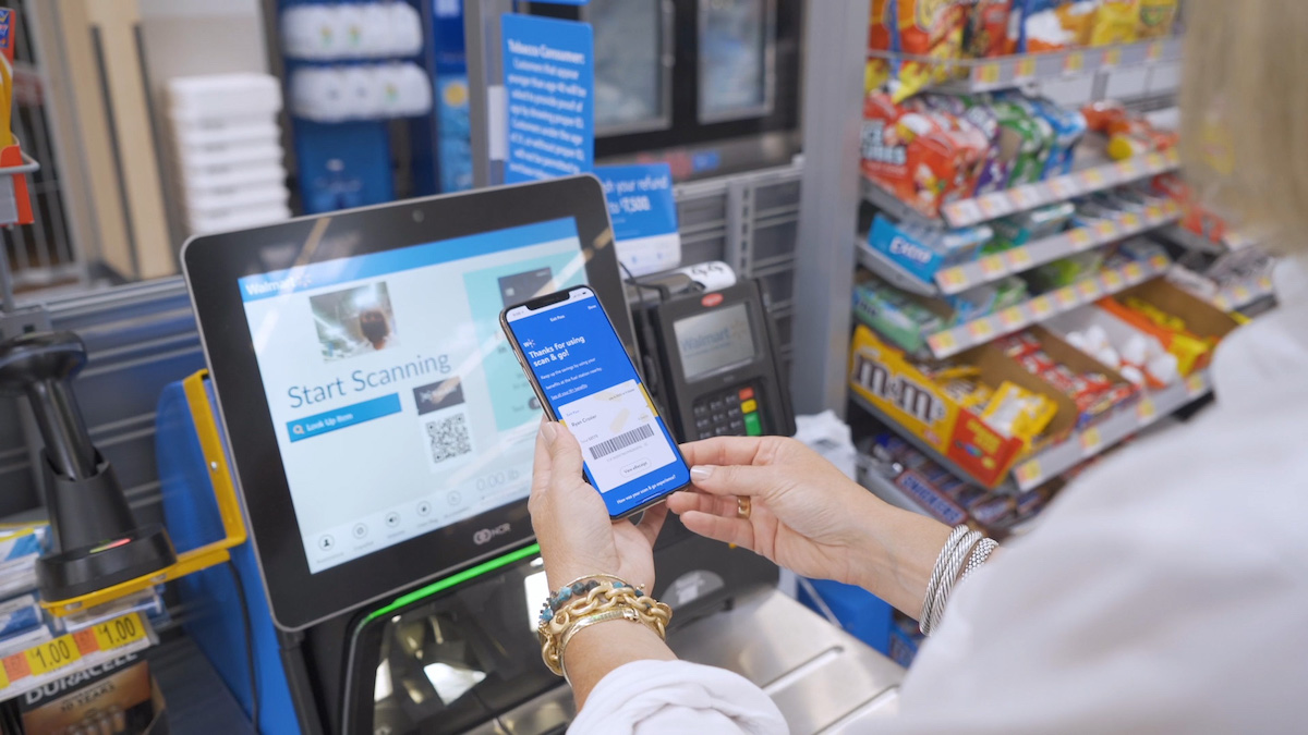 hand holding phone at register at walmart