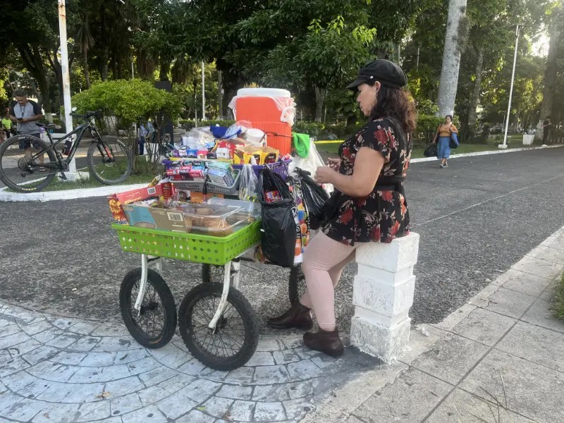 VENDEDORA AMBULANTE EN NUEVA SAN SALVADOR. ELLA APARECE CON UN CELULAR HABLANDO.
