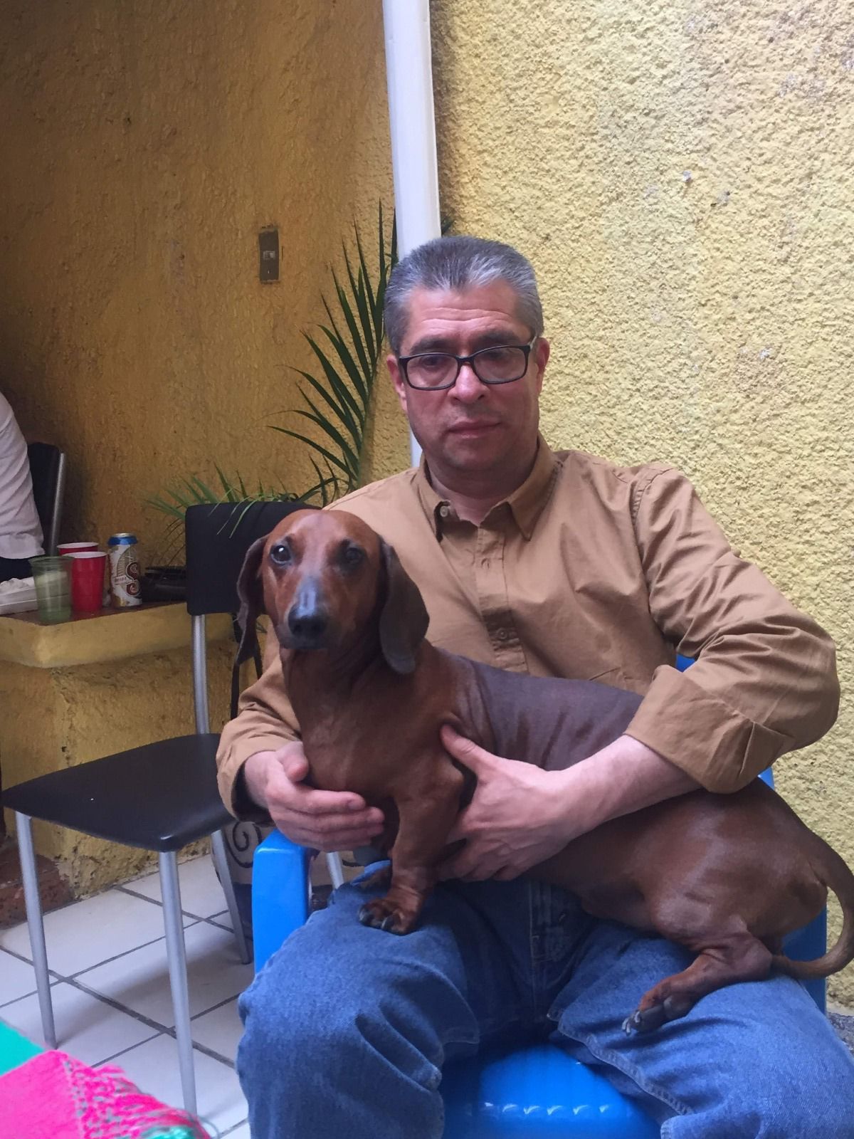 Fotografía de Toño sentado y Ringo arriba de las piernas de Toño, ambos volteando hacia la cámara