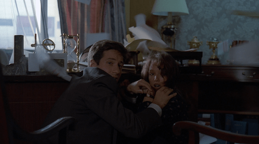 Mulder shields Lauren from papers flying all over the room.