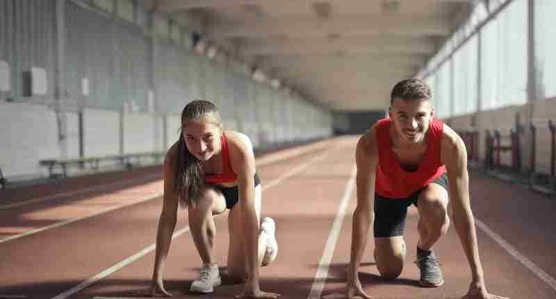 men and woman in red tank top is ready to run on track field