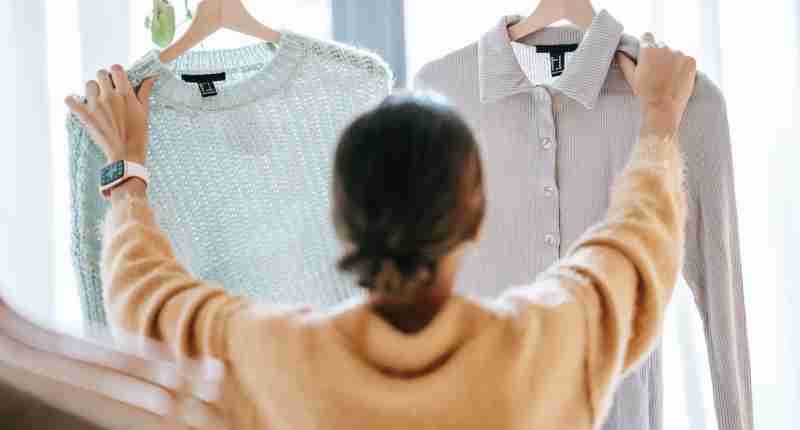 unrecognizable woman demonstrating clothes in store