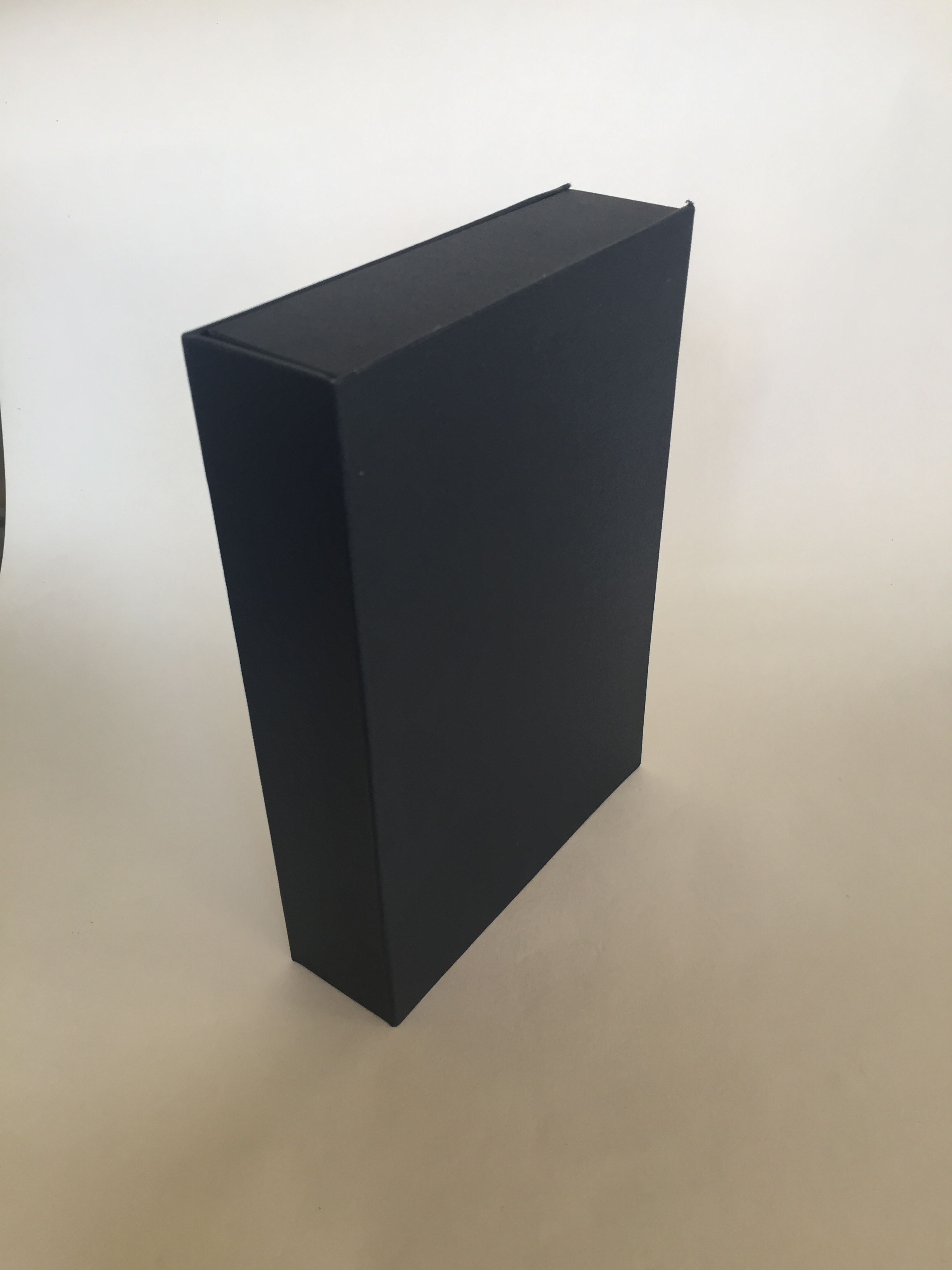 Image of a clamshell or drop spine box made from millboard and covered in blue bookcloth pictured closed and upright