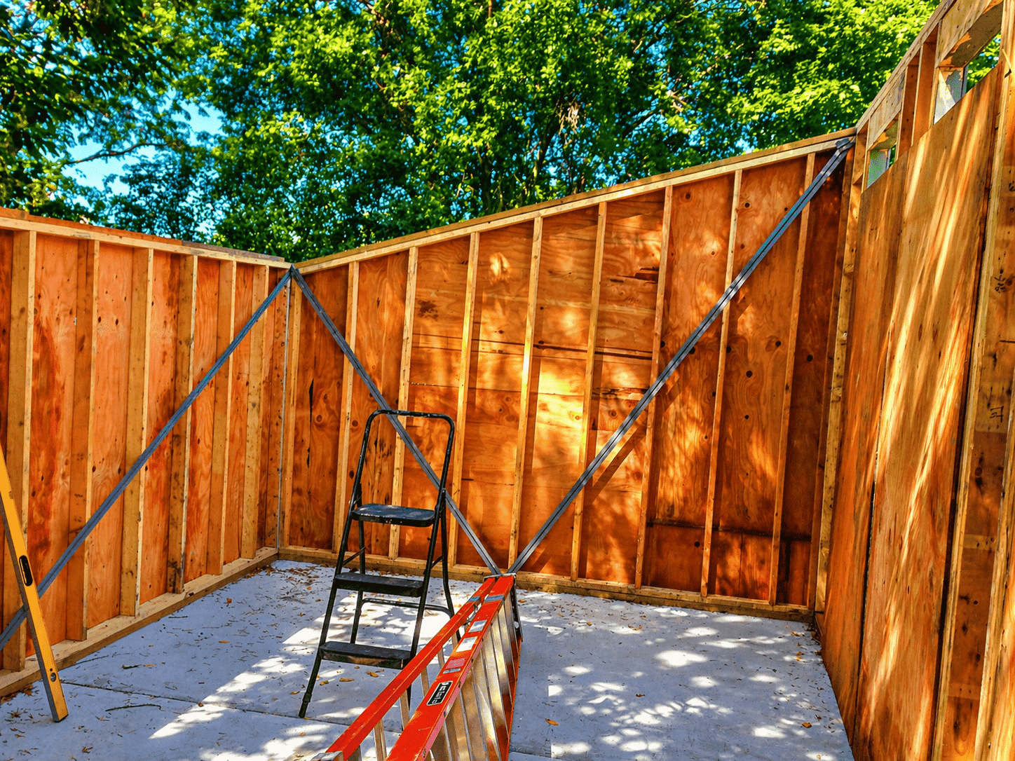 Inside the shed showing four framed walls standing with diagonal steel braces