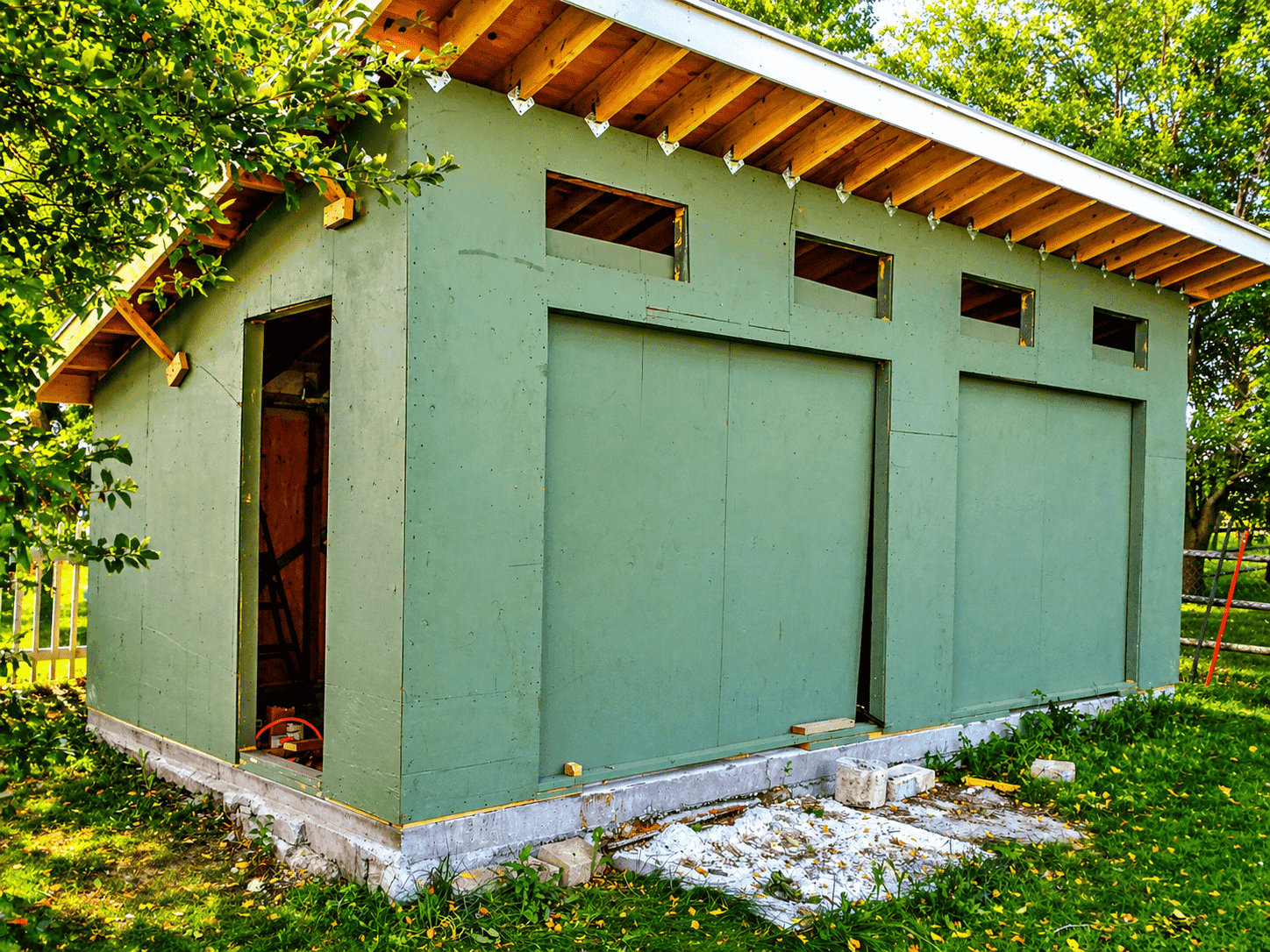Shed with Hardie fiber cement panels installed showing aluminum reveal channels between panels
