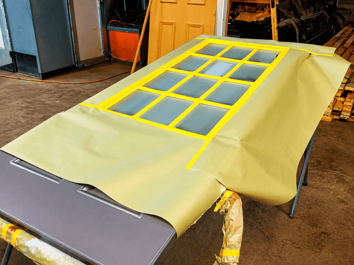 Garage door masked with yellow tape windows to create tinted glass illusion