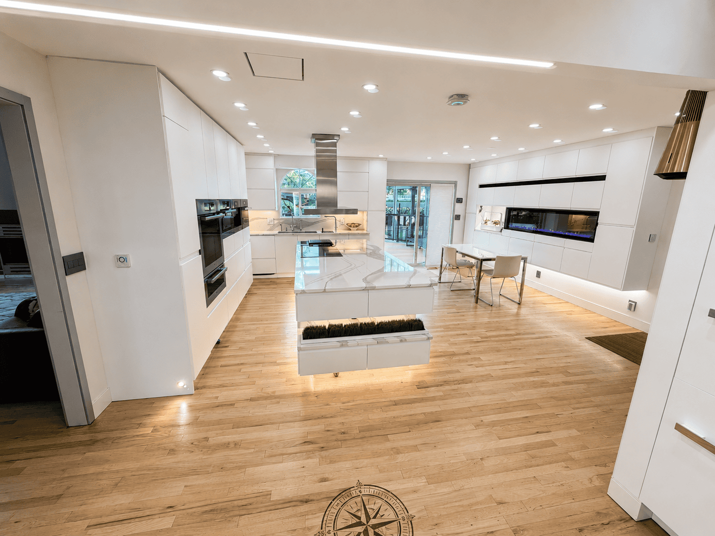 IKEA kitchen appliances overview: white SEKTION cabinets with hardwood floors and central island.