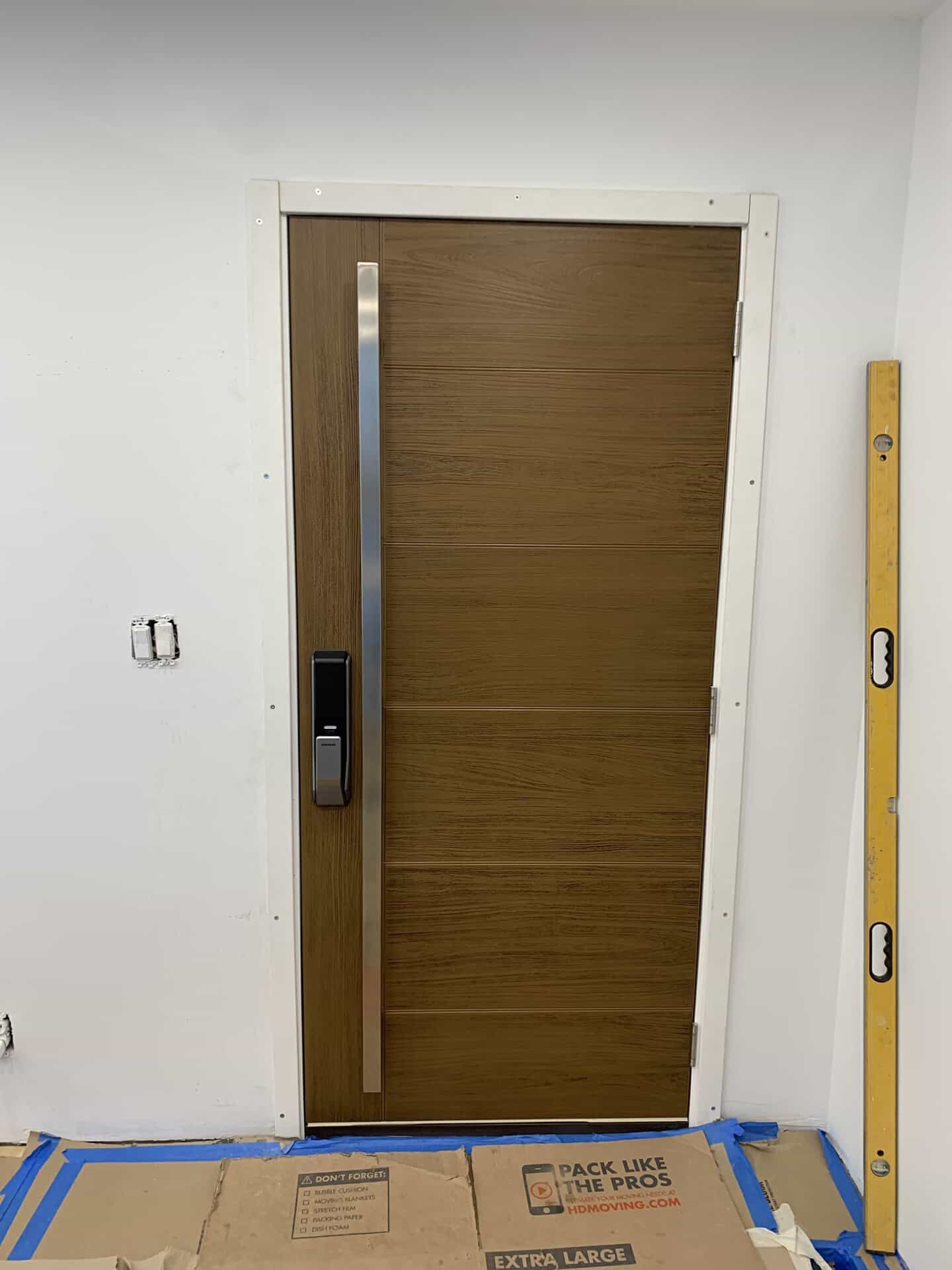 Interior wooden door with security lock and vertical handle in a new building.