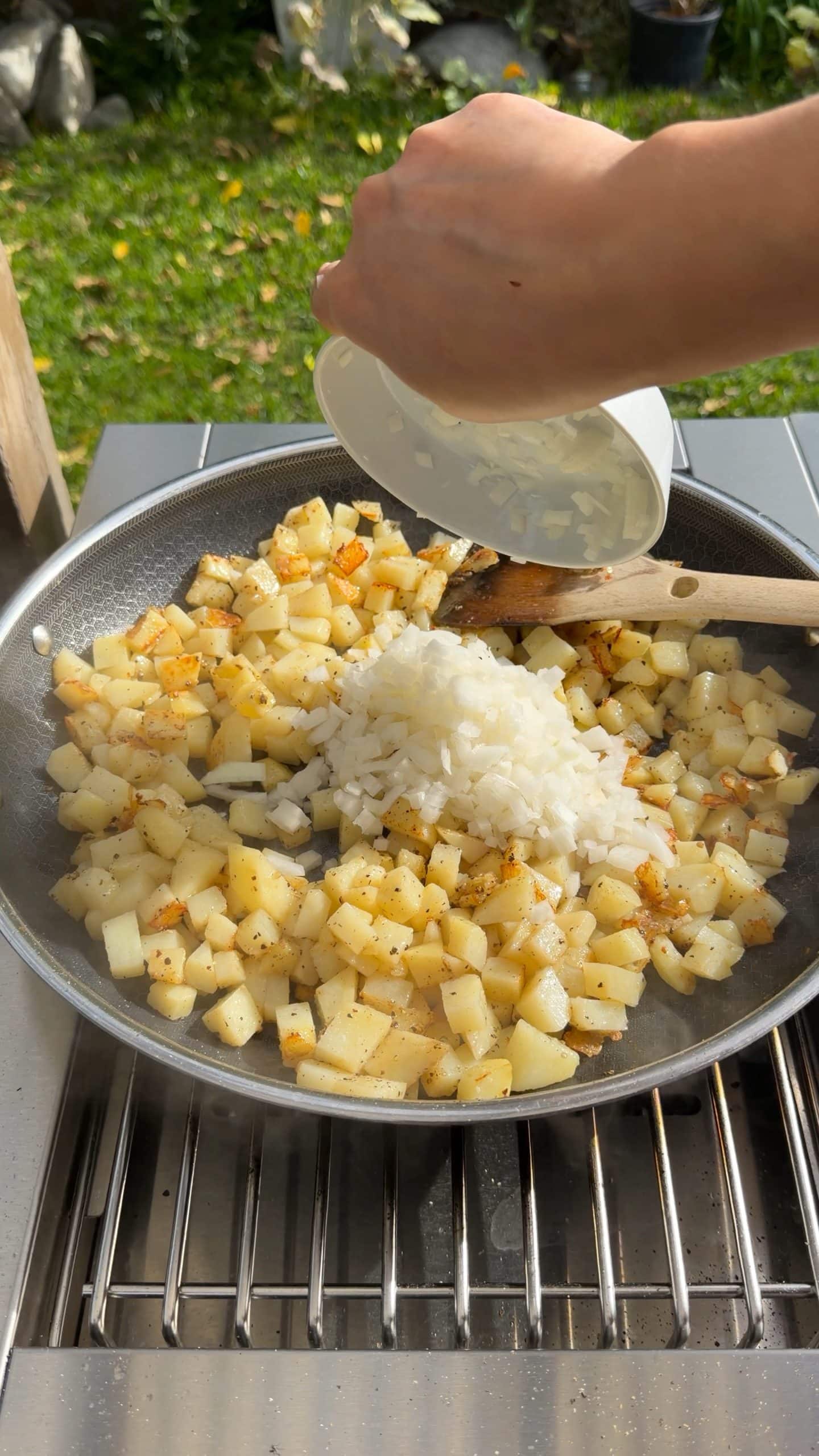 Diced onion added to skillet after potatoes start to crisp
