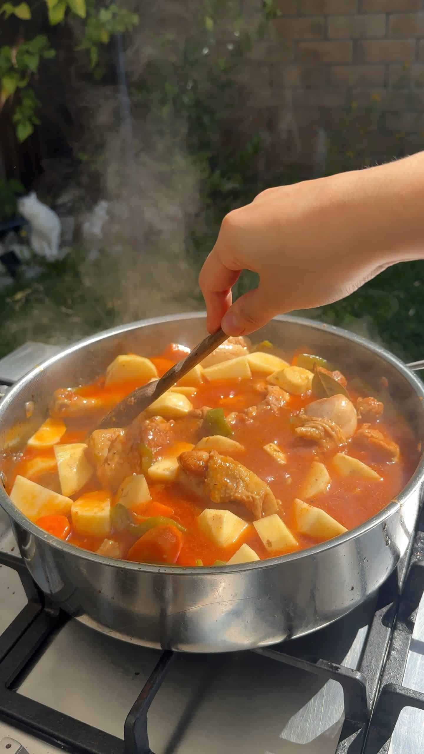 Stirring the stew after adding potatoesStirring the stew after adding potatoes