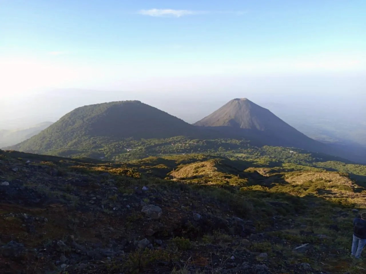 Impresionante vista panorámica de las colinas verdes y los picos volcánicos de El Salvador bajo un cielo claro.
