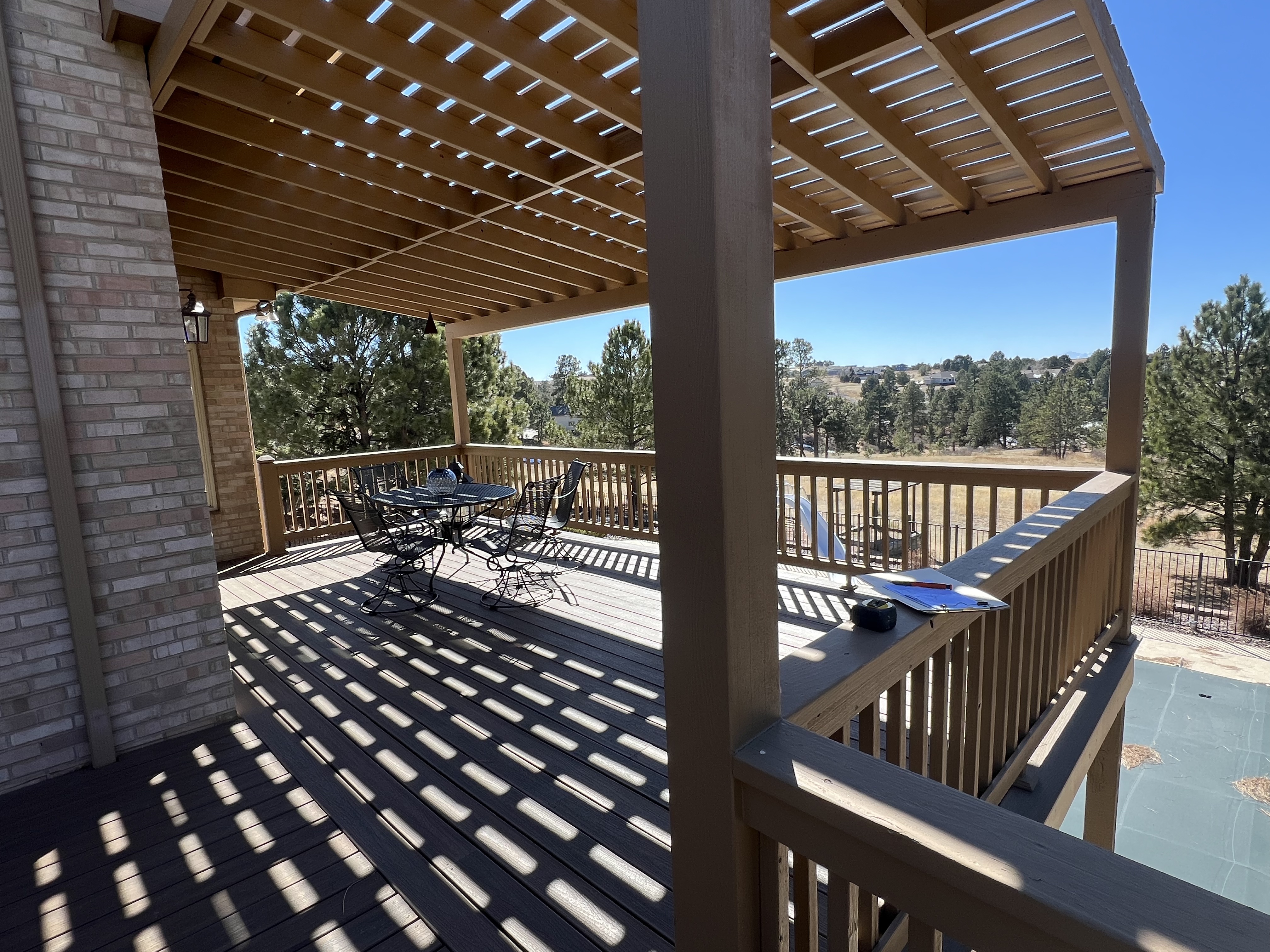 Composite deck with wood pergola and wood railing