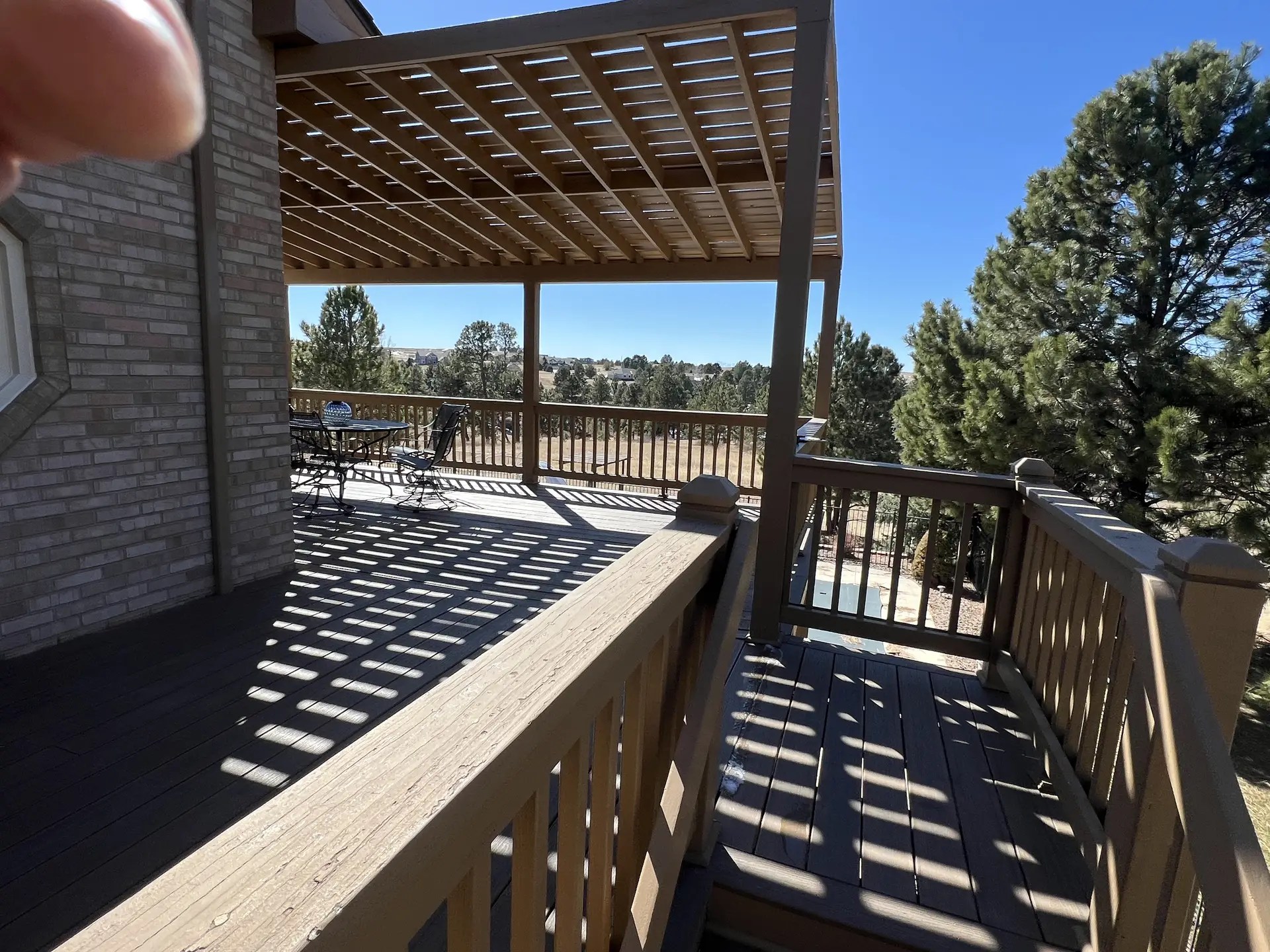 Composite deck with wood pergola and wood railing