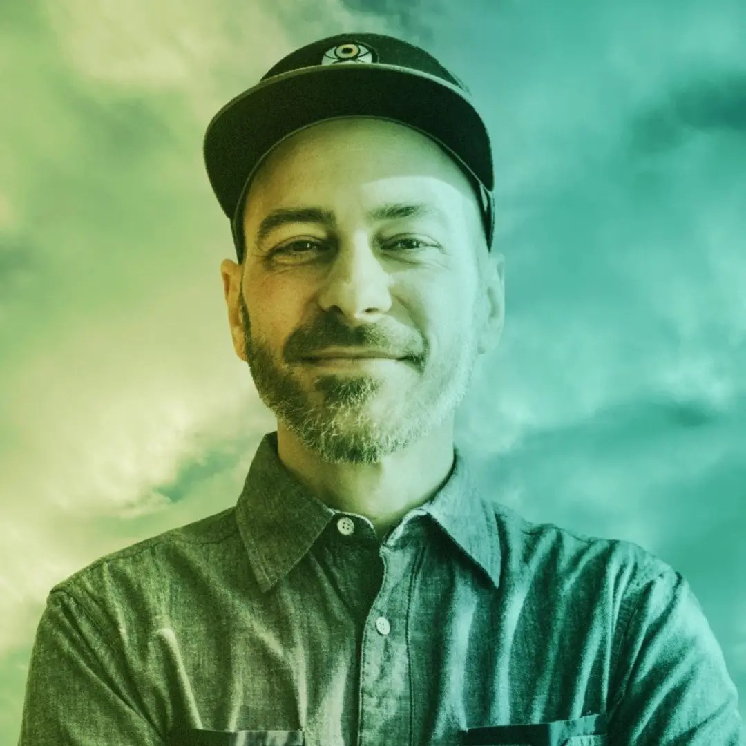 Headshot of Drew Mueske with green and blue background
