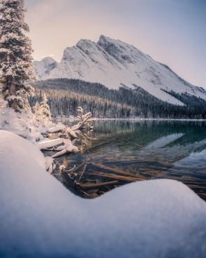 Alpine lakes really look incredible with a layer of fresh snow surrounding them. Elbow Lake, Alberta. [OC] [2048×2560]