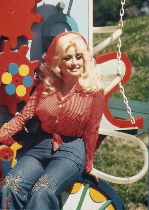 Singer Dolly Parton posing in some kind of attraction, circa mid 1970s.