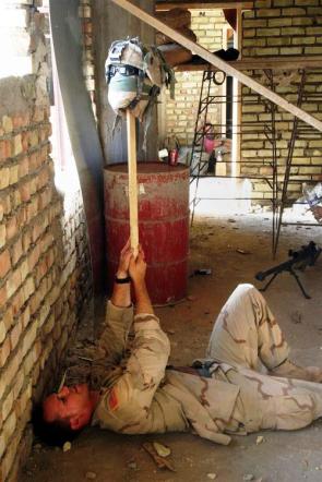 A U.S. sniper used his helmet as a Decoy to find the enemies position in Najaf, Iraq, August 2004. [500 × 750]