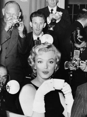 Marilyn Monroe surrounded by journalists at the Savoy Hotel during a press conference on July 15, 1956.