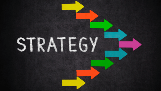 image showing the word "strategy" written in a bold font and all caps, with multiple arrows of various colors pointing to the right side of the image. The arrows could are straight and thick. The use of different colors convey different aspects of the strategy being depicted. Overall, the image suggest movement, progress, and forward-thinking as key components of an effective strategy.