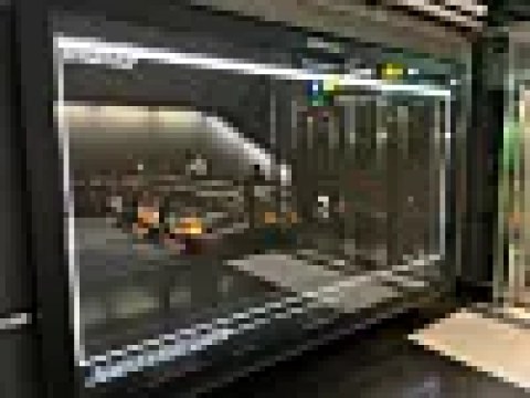 A large transit-station screen displays a GNU GRUB boot menu with UEFI and DMS options beside an escalator.