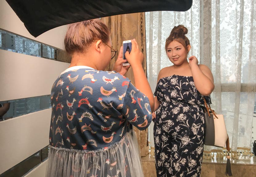 Plus-size modeling agent Huang Fei (left) takes sample photos of model hopeful Wang Jialin in Guangzhou, Guangdong province, June 20, 2017. Fan Yiying/Sixth Tone