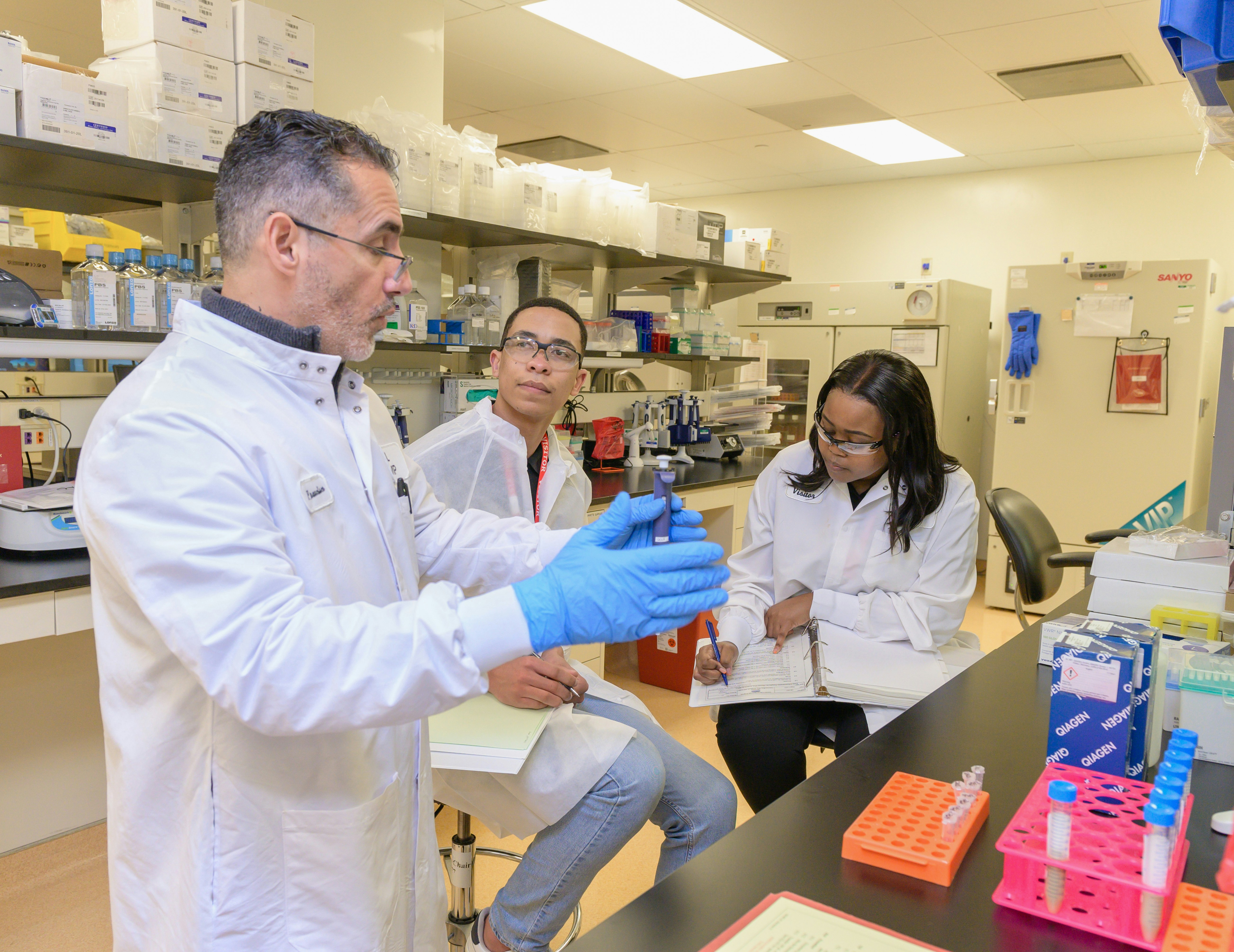 A Group Of People In A Lab Looking At Something Photo Free Laboratory