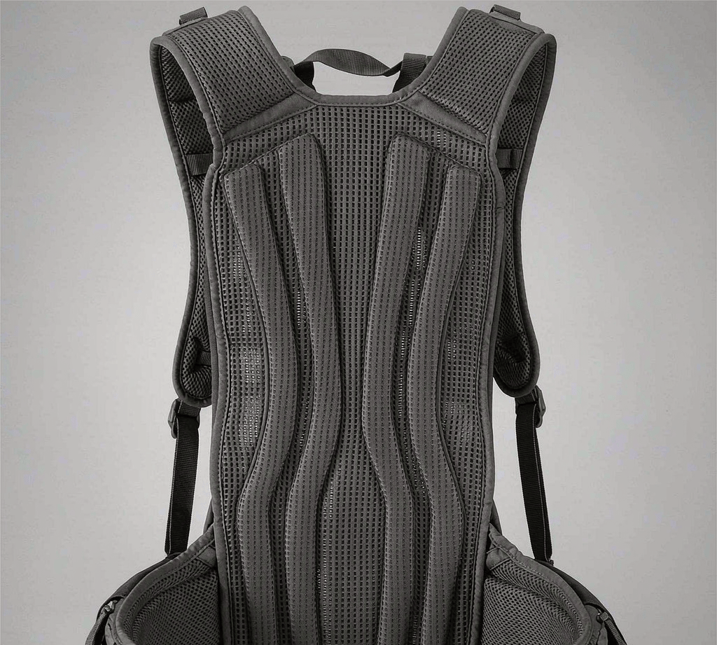 Back of a backpack showing a 3D spacer mesh ventilation structure with vertical airflow channels