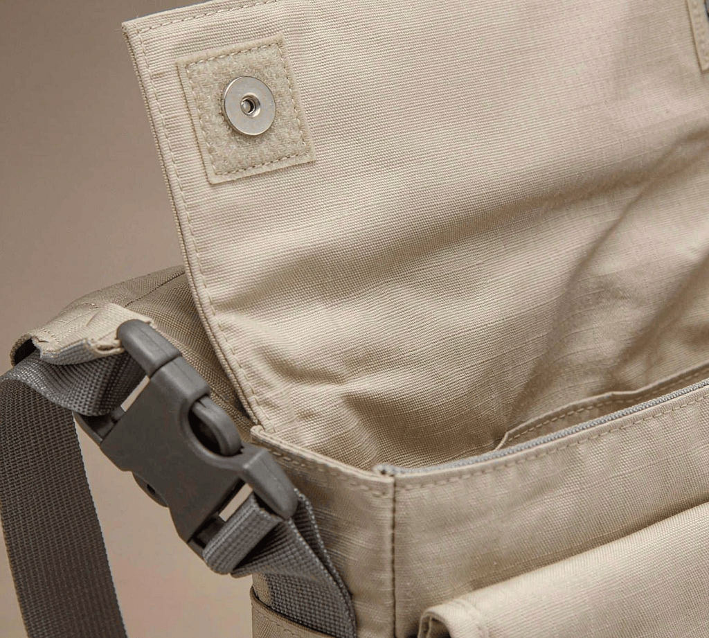 Close-up of a canvas tote showing a magnetic snap, a side-release buckle, and hook-and-loop fastener.