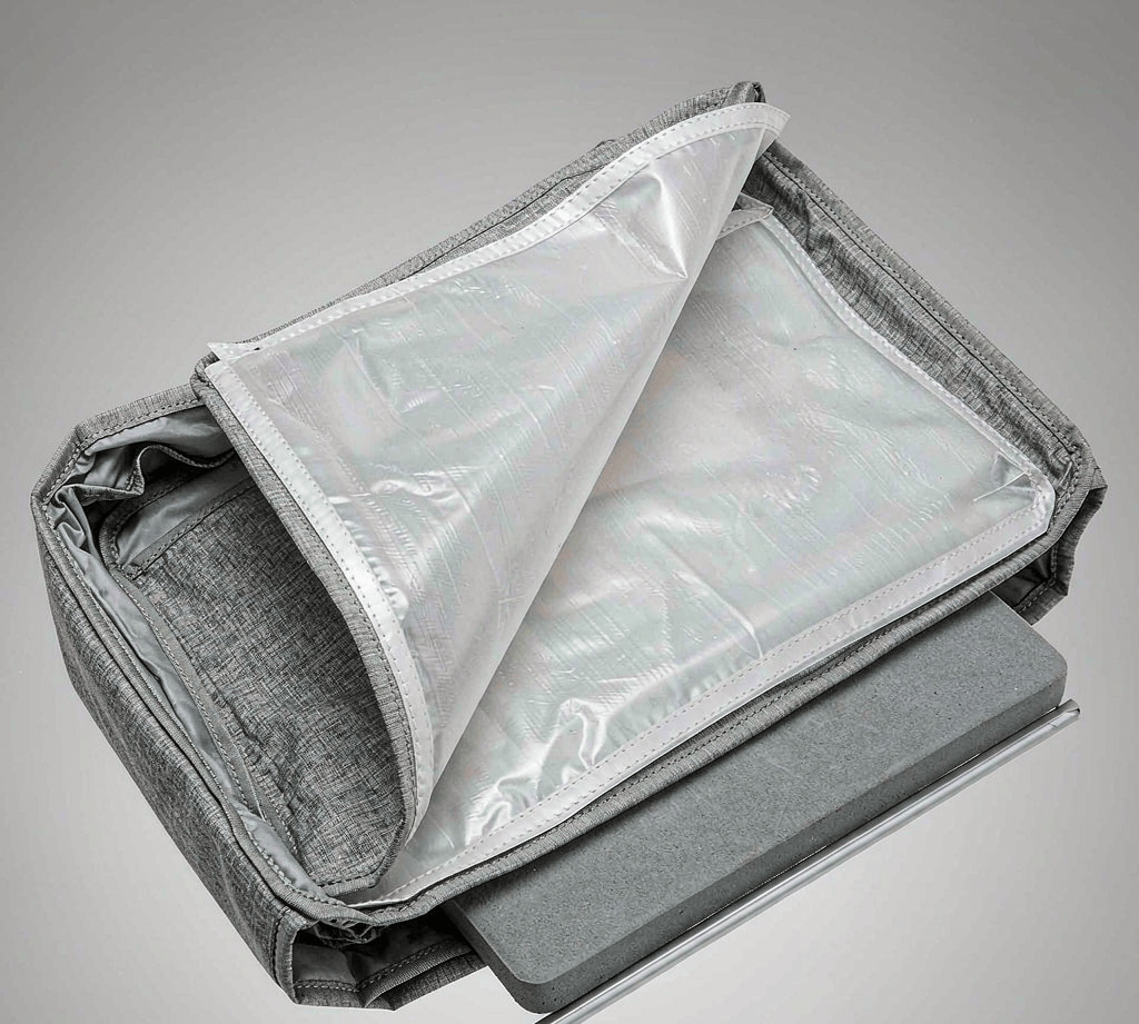 Cutaway of a backpack back panel showing a removable translucent polyethylene frame sheet sliding out of a fabric sleeve beside EVA foam padding and a metal stay