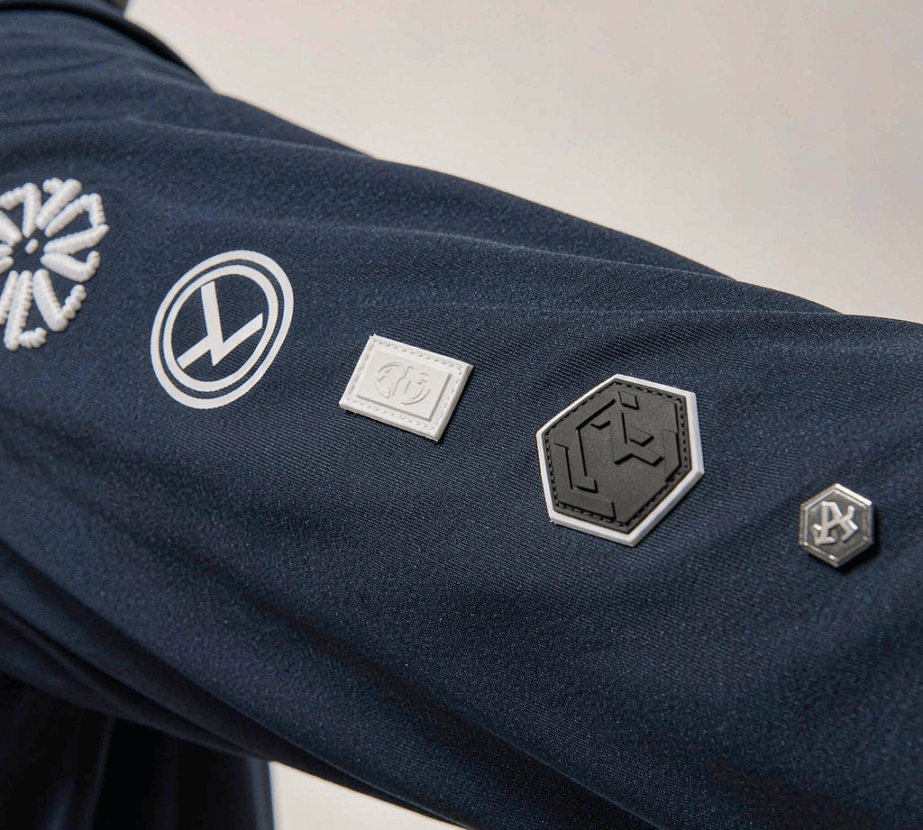 Bag logo application methods shown side by side on one fabric panel: embroidery, screen print, woven label, debossed patch, and a metal badge