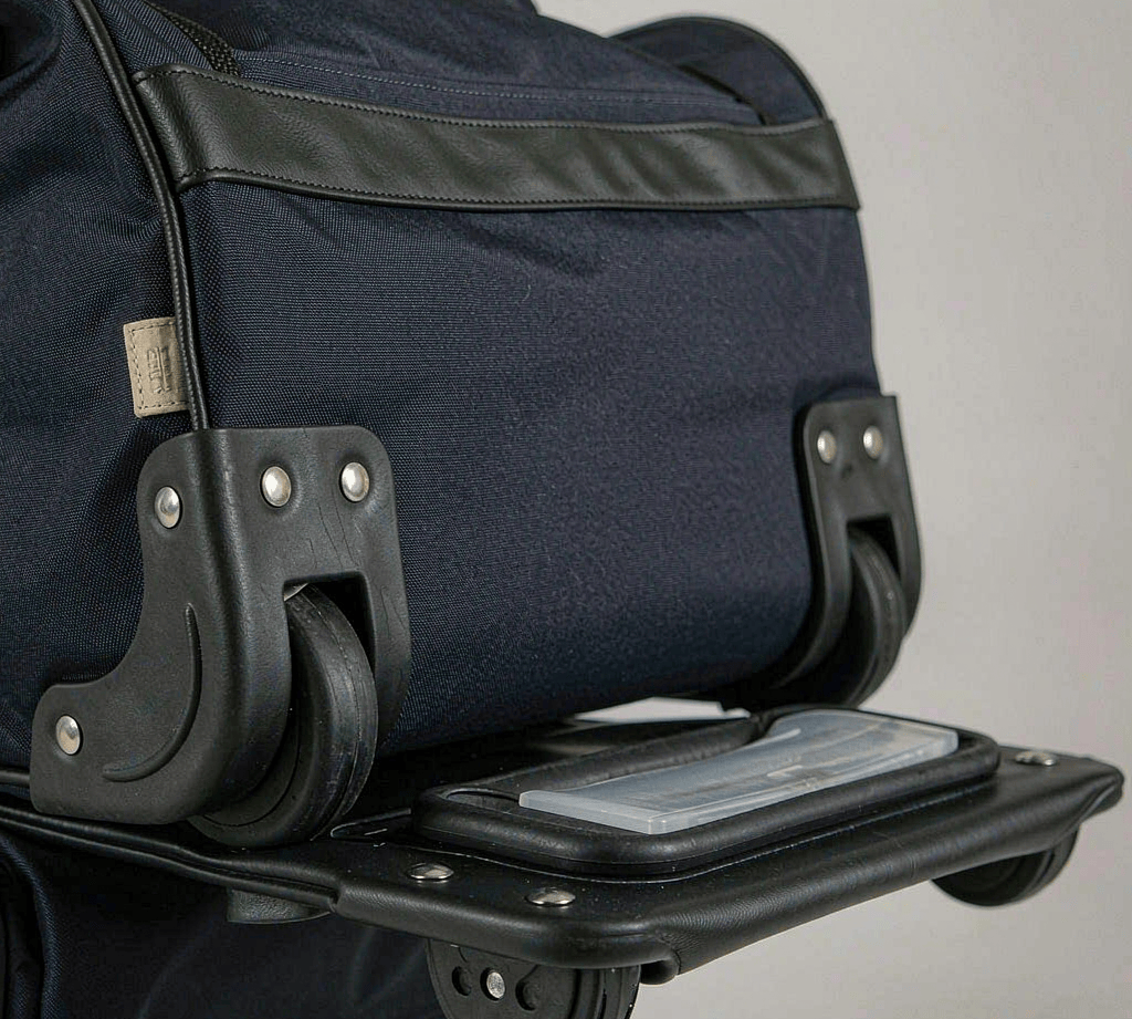 Rubber and TPU corner protectors riveted onto the base corners of a travel duffel bag