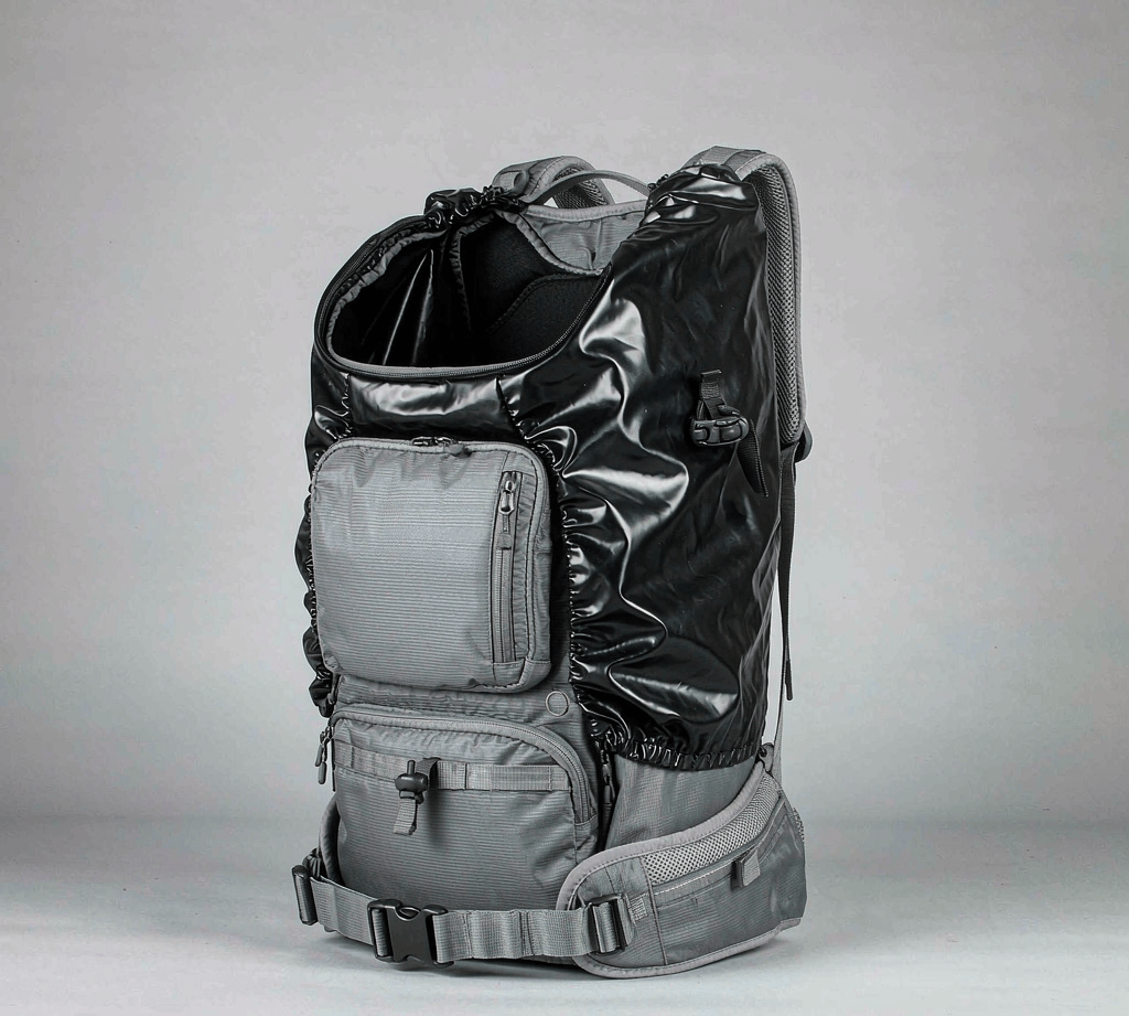 Travel backpack wearing a snug waterproof rain cover with an elastic hem and a side buckle strap