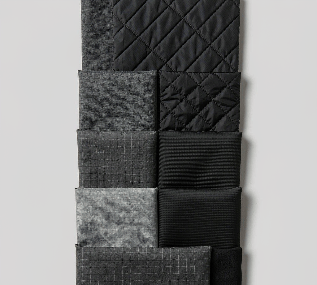 Assorted backpack fabric swatches showing coated nylon and polyester materials