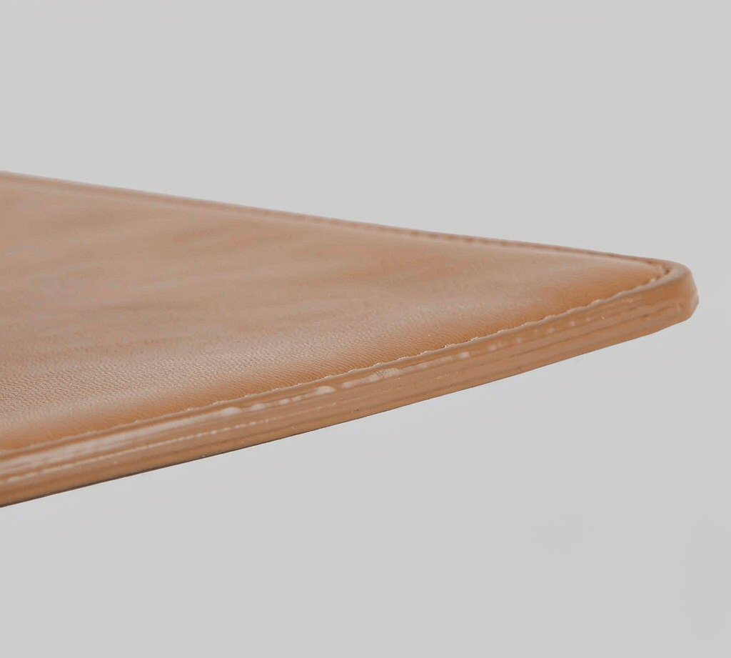 Close-up of a smooth multi-coat painted edge on a tan PU bag panel
