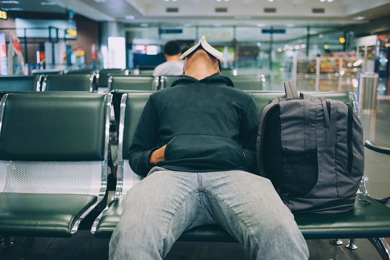 An airport traveler exhausted from his journey. He could use the energy boost from an IV treatment from Integrated Mobile Health.