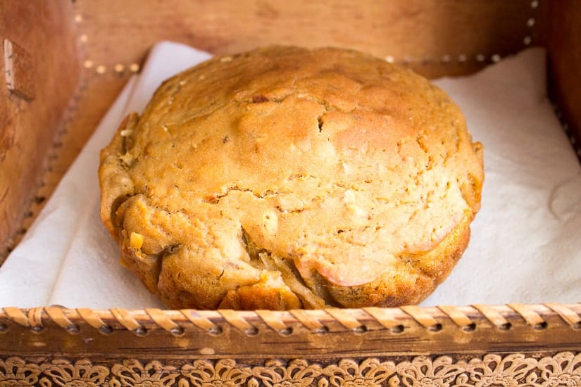 Side view of a spiced beer bread placed on a brown container.