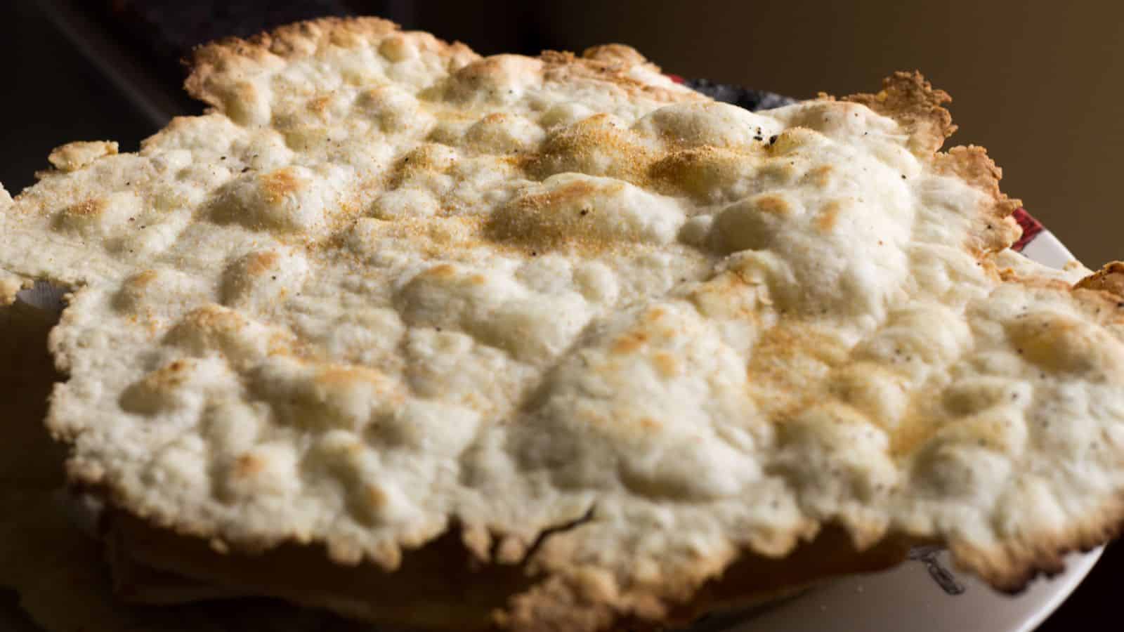 Close-up of a freshly baked apple pie with a golden, flaky crust sprinkled with sugar, displayed on a plate. The sunlight highlights the texture of the pie crust in this Auto Draft.